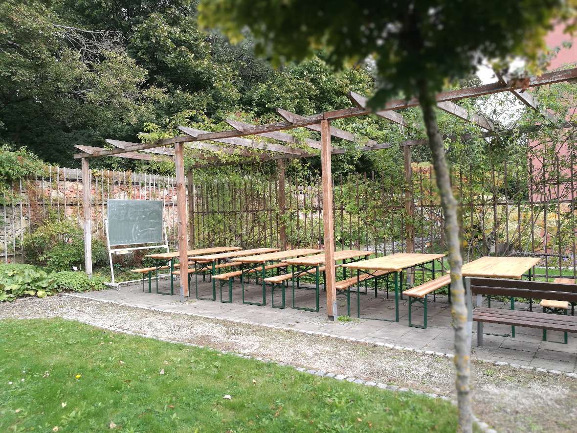 Pergola mit Tisch- und Sitzbank-Kombination und eine grüne Tafel als grünes Klassenzimmer