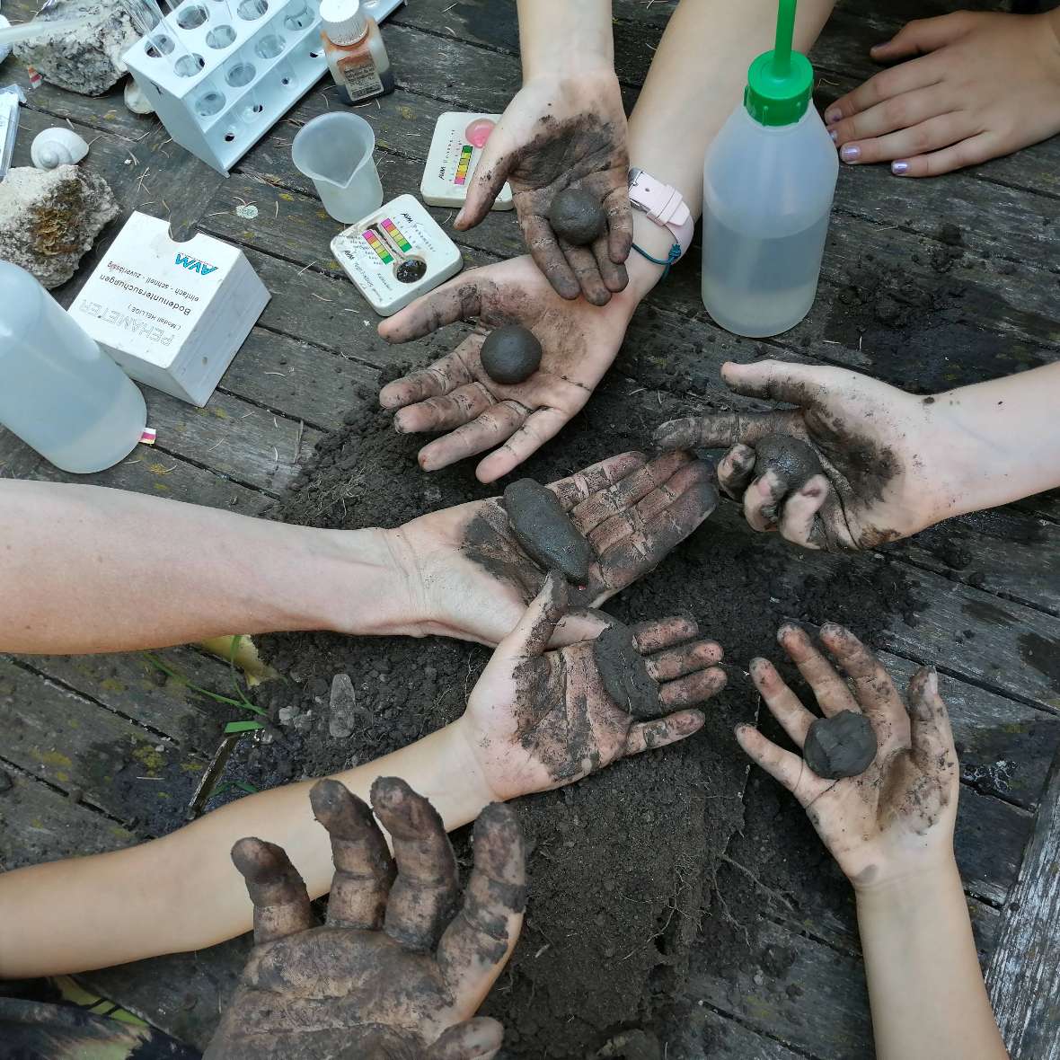 Kinder nehmen Fingerproben um den Tongehalt des Bodens zu bestimmen