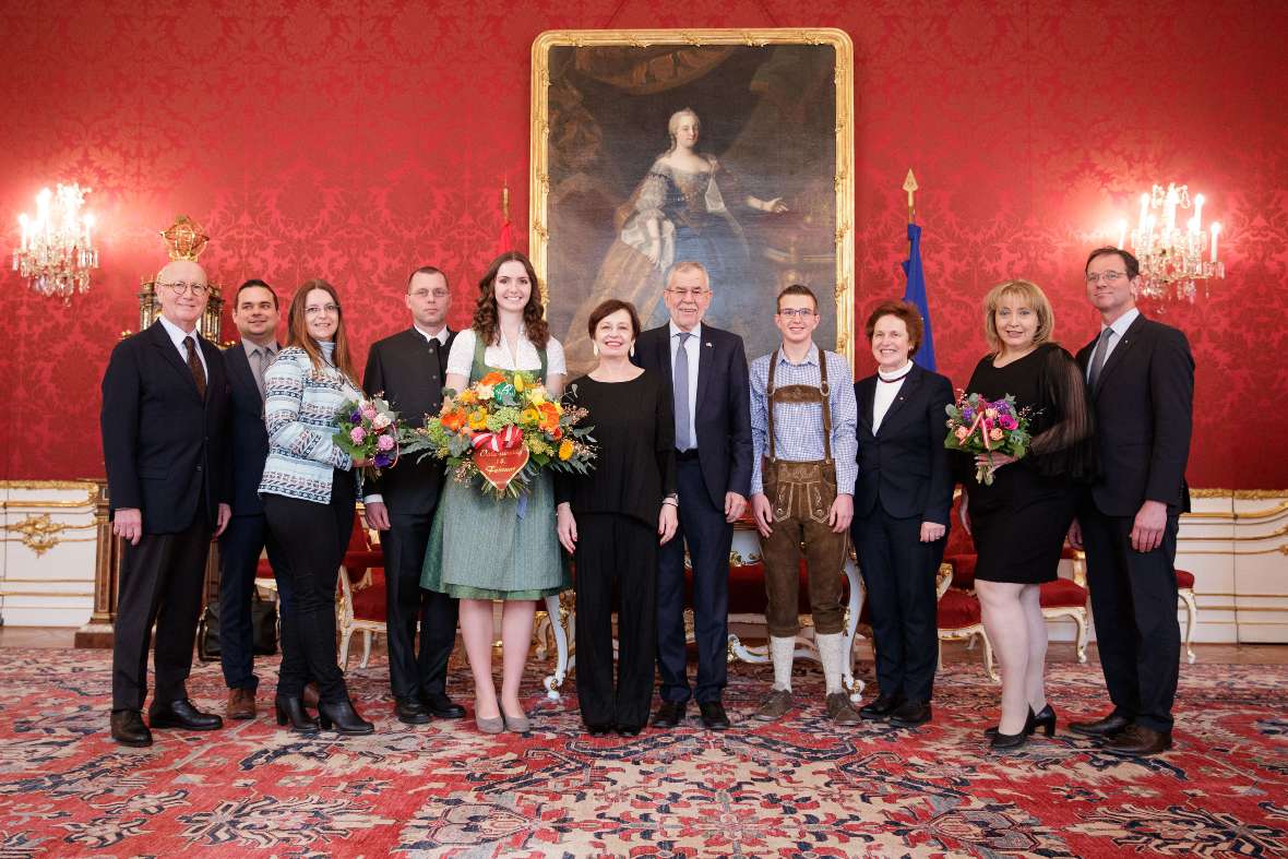 zu sehen sind Personen in einem Halbkreis aufgestellt in einem Saal der Hofburg; in der Mitte Herr Bundespräsident Van der Bellen und seine Gattin