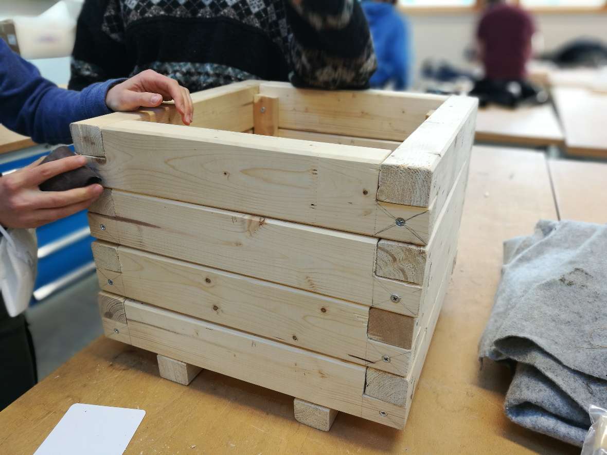 Schülerinnen fertigen einen Pflanzkübel aus Holz