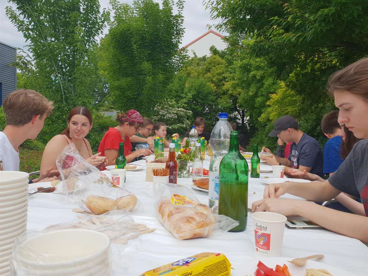 Schülerinnen und Schüler des 2 GB-Jahrganges bei einer Jause an einer Tafel in der Außenstelle Jägerhausgasse