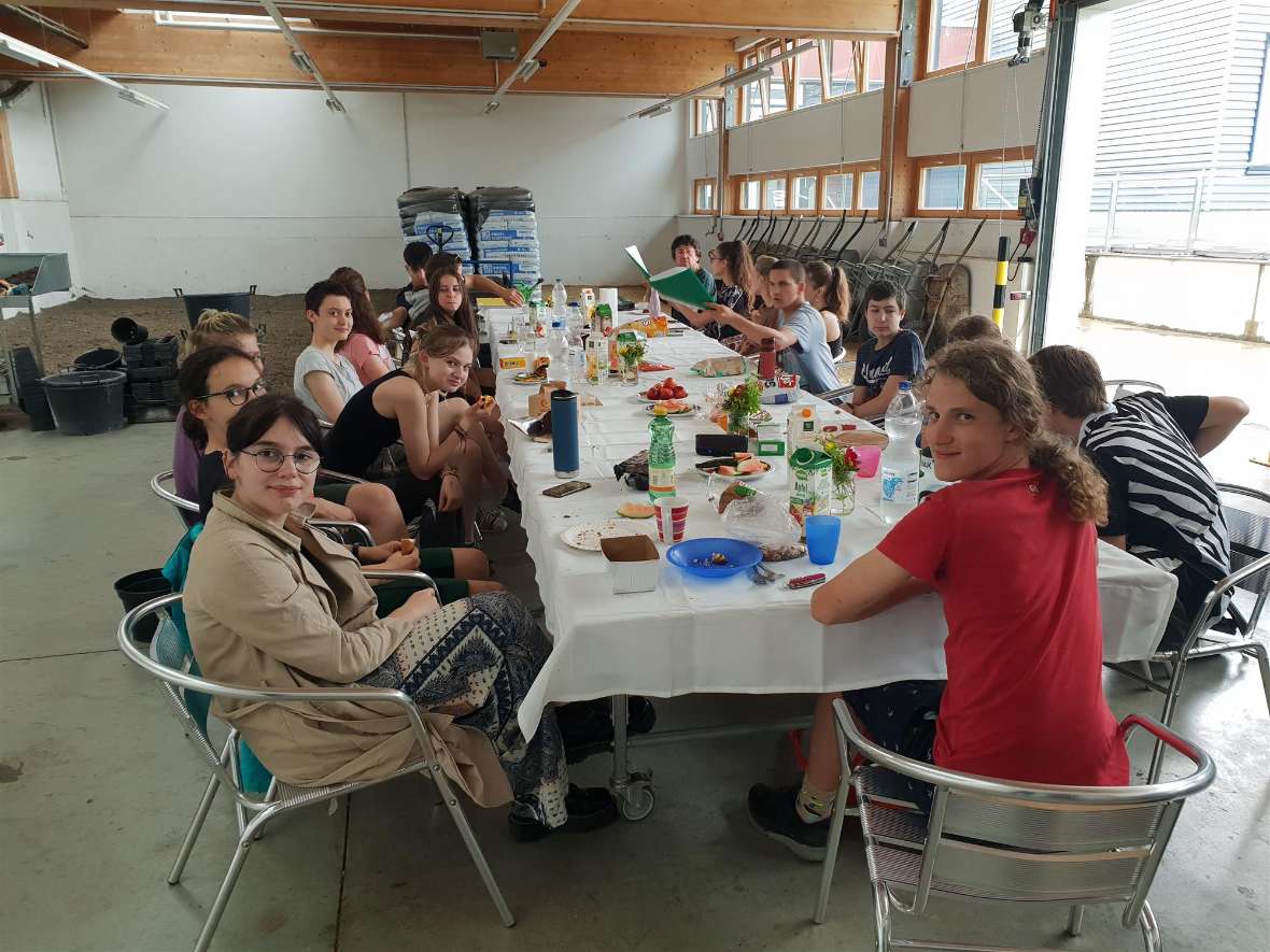 Schülerinnen und Schüler des 2 GLG-Jahrganges bei einer Jause an einer Tafel in der Außenstelle Jägerhausgasse