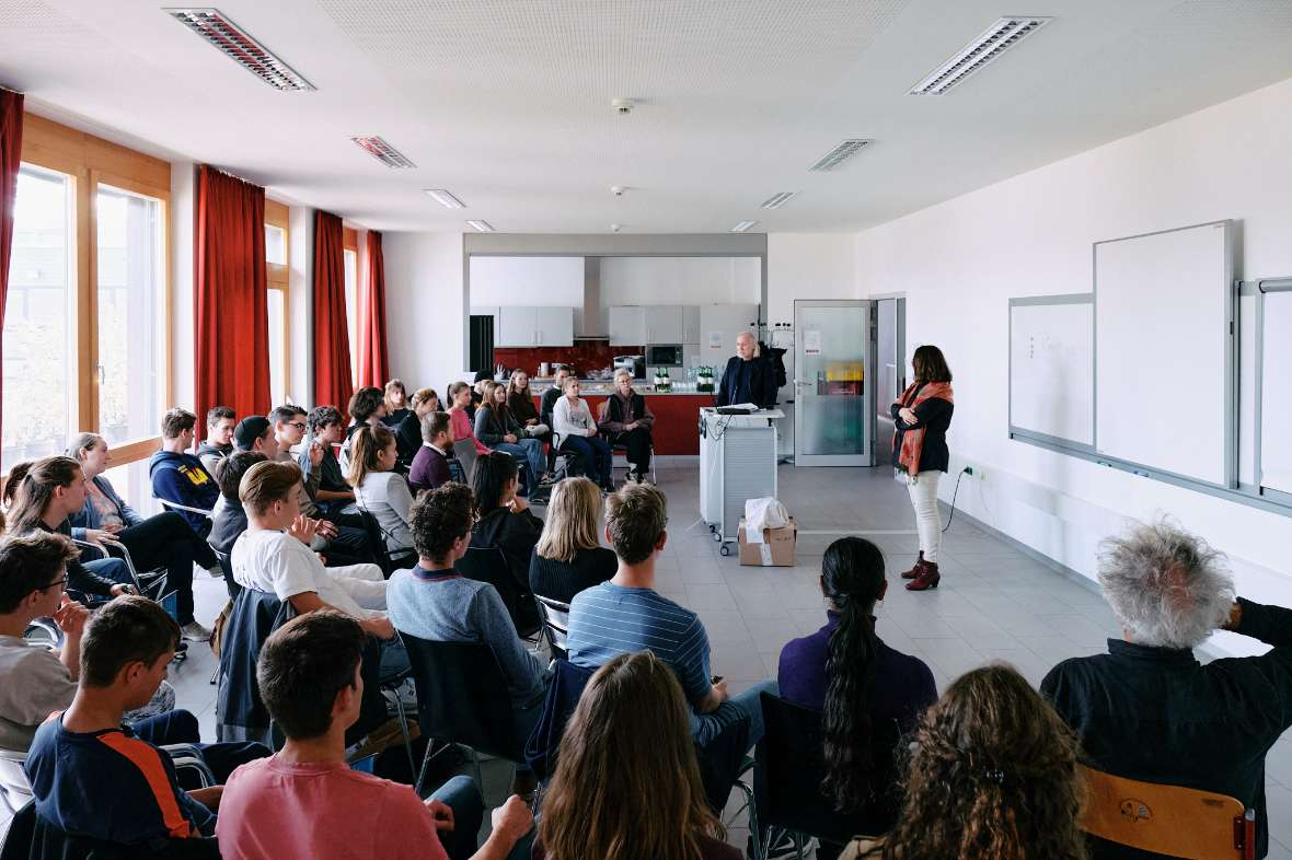 Schülerinnen und Schüler sitzen in einem Seminarraum