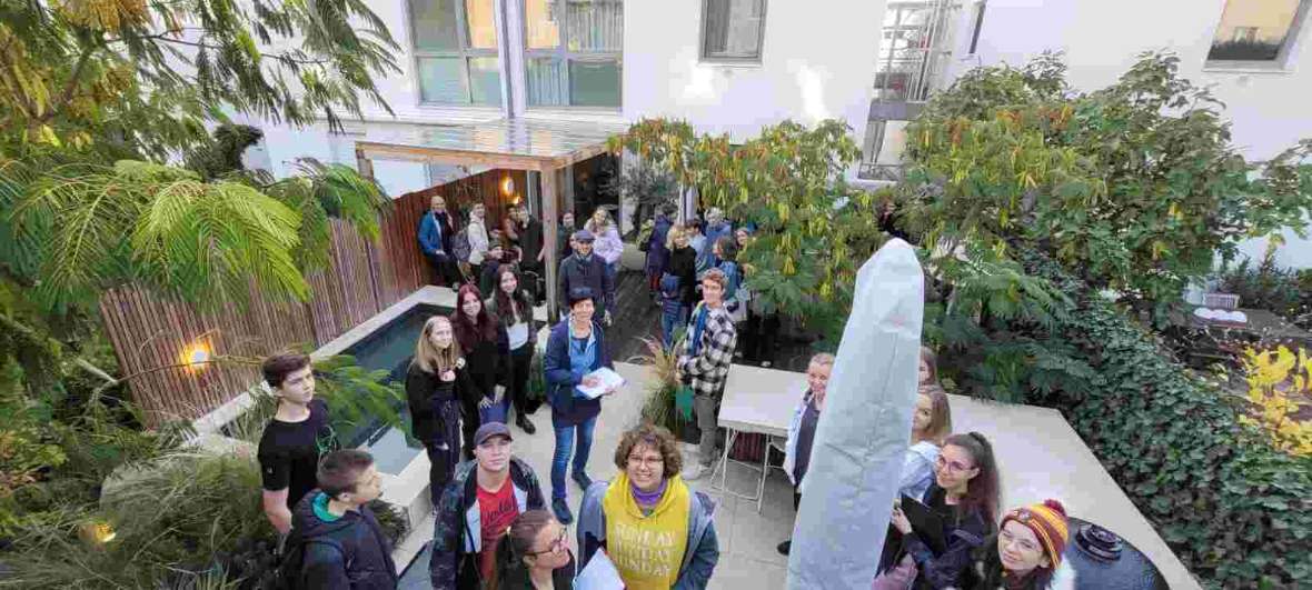 Schüler:innen stehen in einem kleinen Hausgarten