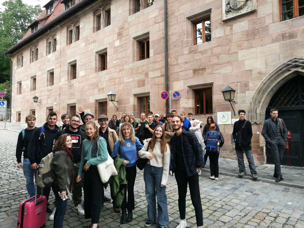 Schülerinnen und Schüler stehen vor der ehemaligen Kaiserstallung in Nürnberg