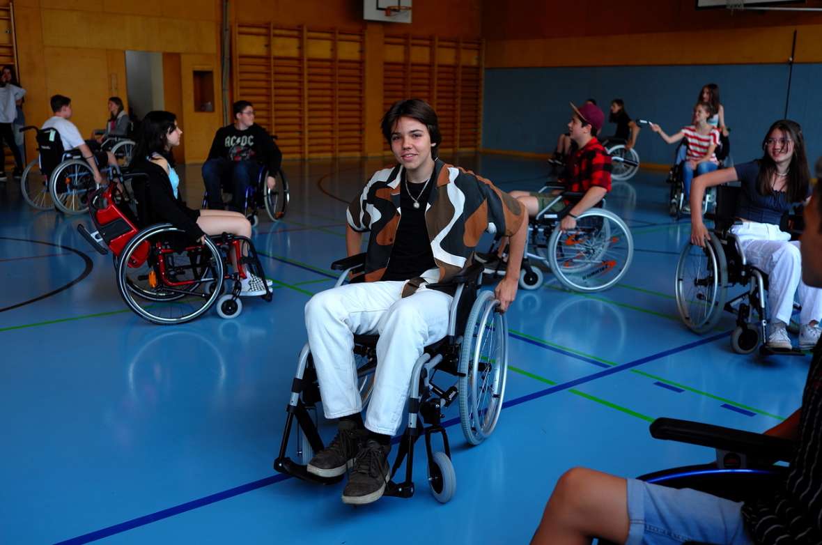 Schülerinnen und Schüler im Rollstuhl im Turnsaal