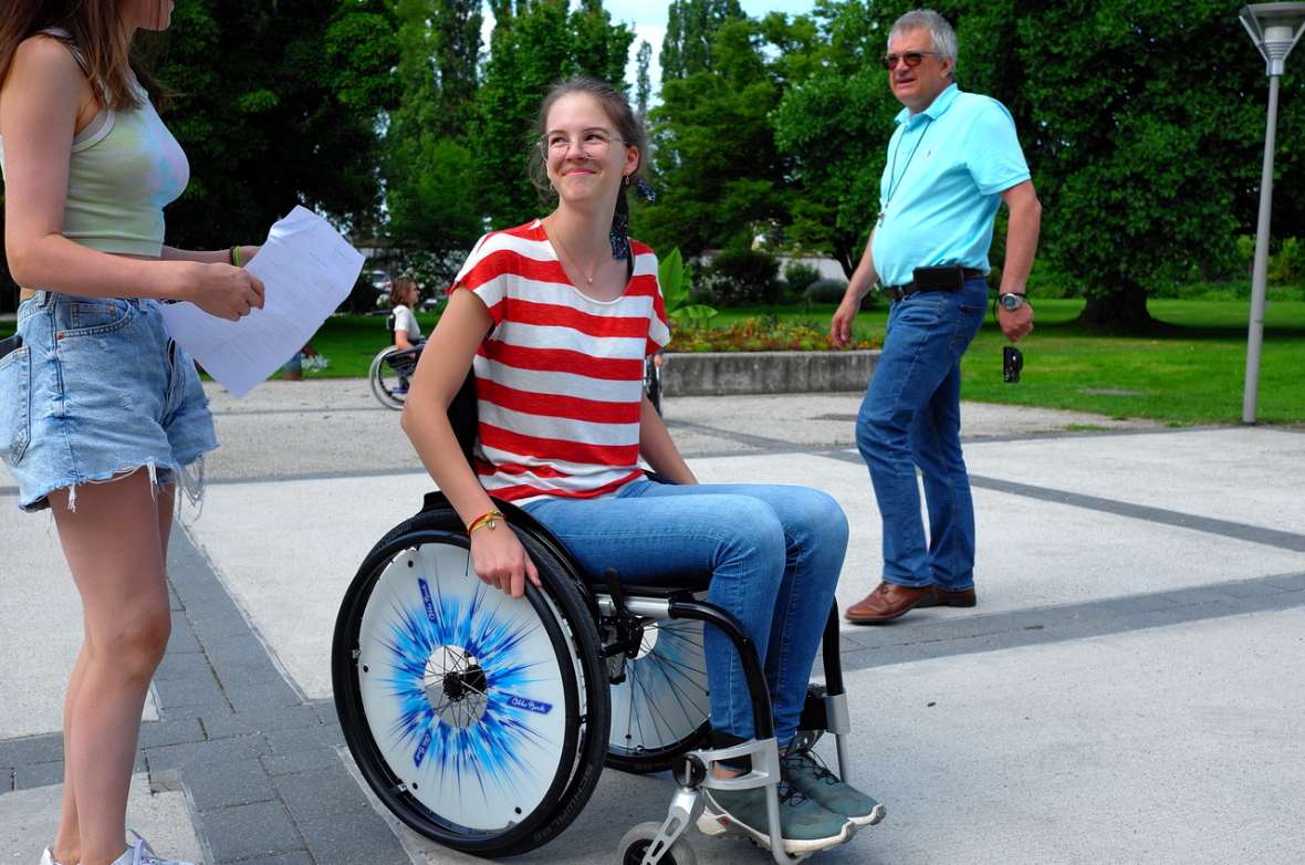 Schülerin probiert Fahren mit dem Rollstuhl auf einer ebenen Fläche aus