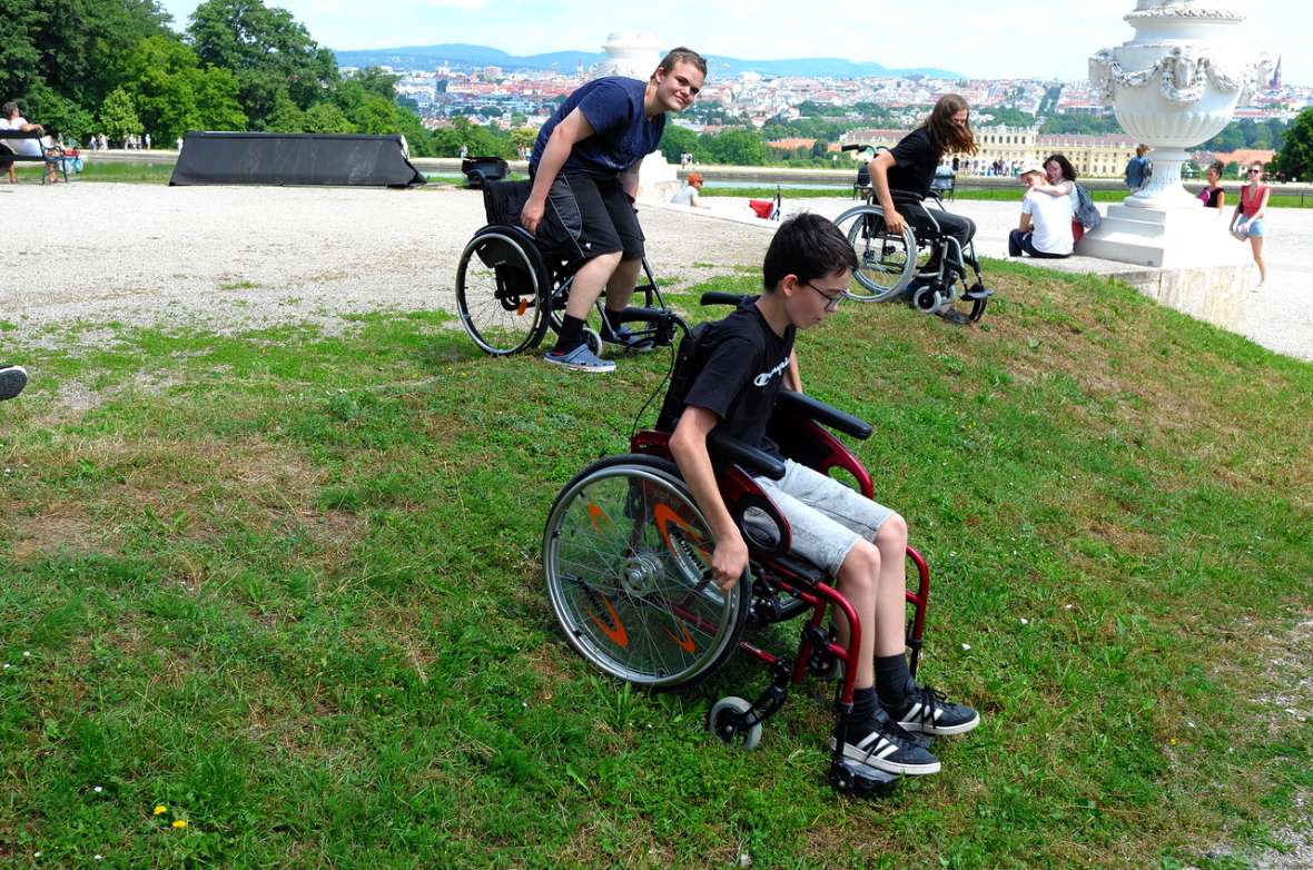 Schüler probieren das Befahren einer Böschung im Rollstuhl aus