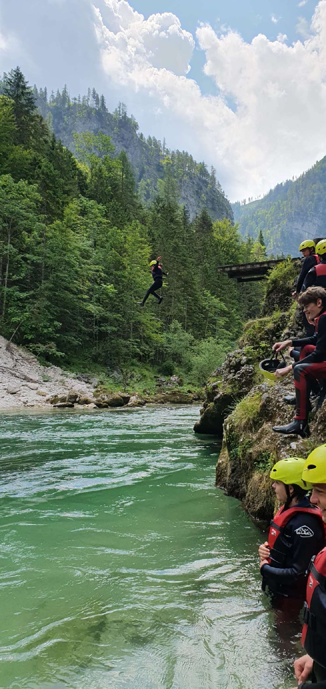 Schüler*innen bereiten sich durch einen Sprung ins Wasser aufs Rafting vor