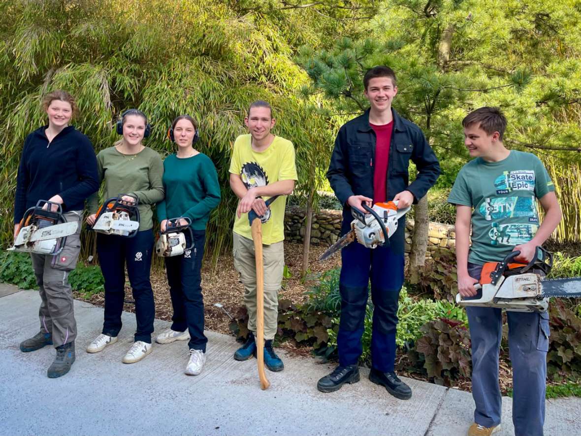 Gruppenfoto: 3 Schülerinnen, 3 Schüler, 5 Schüler:innen halten eine Motorsäge in der Hand.