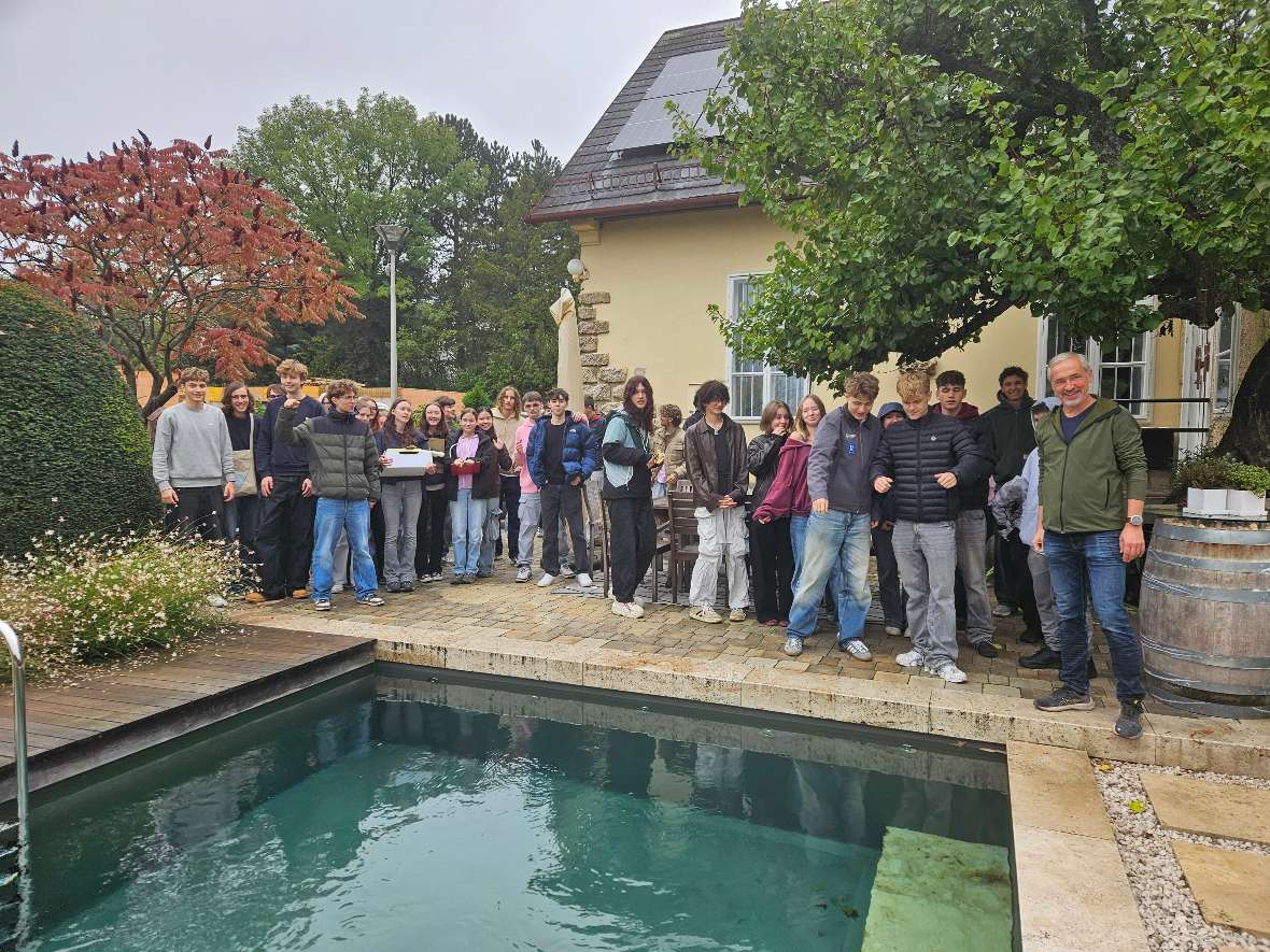 Schülerinnen und Schüler stehen hinter einem Naturpool