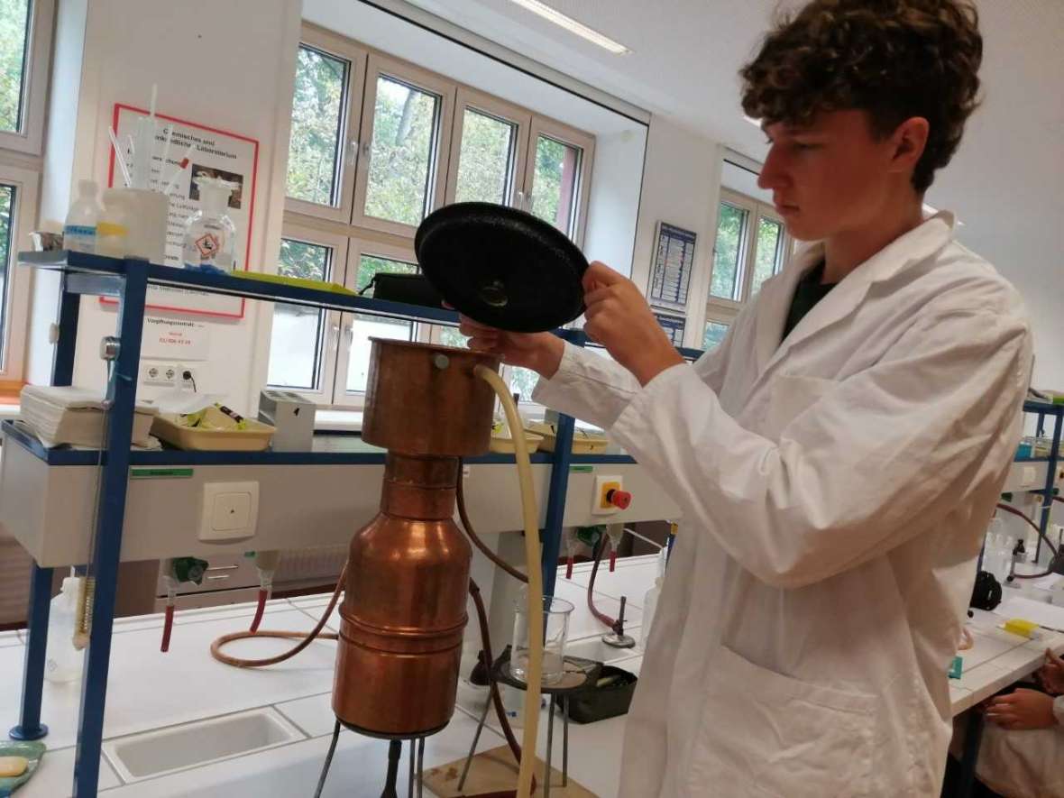 Schüler mit weißem Mantel im Labor