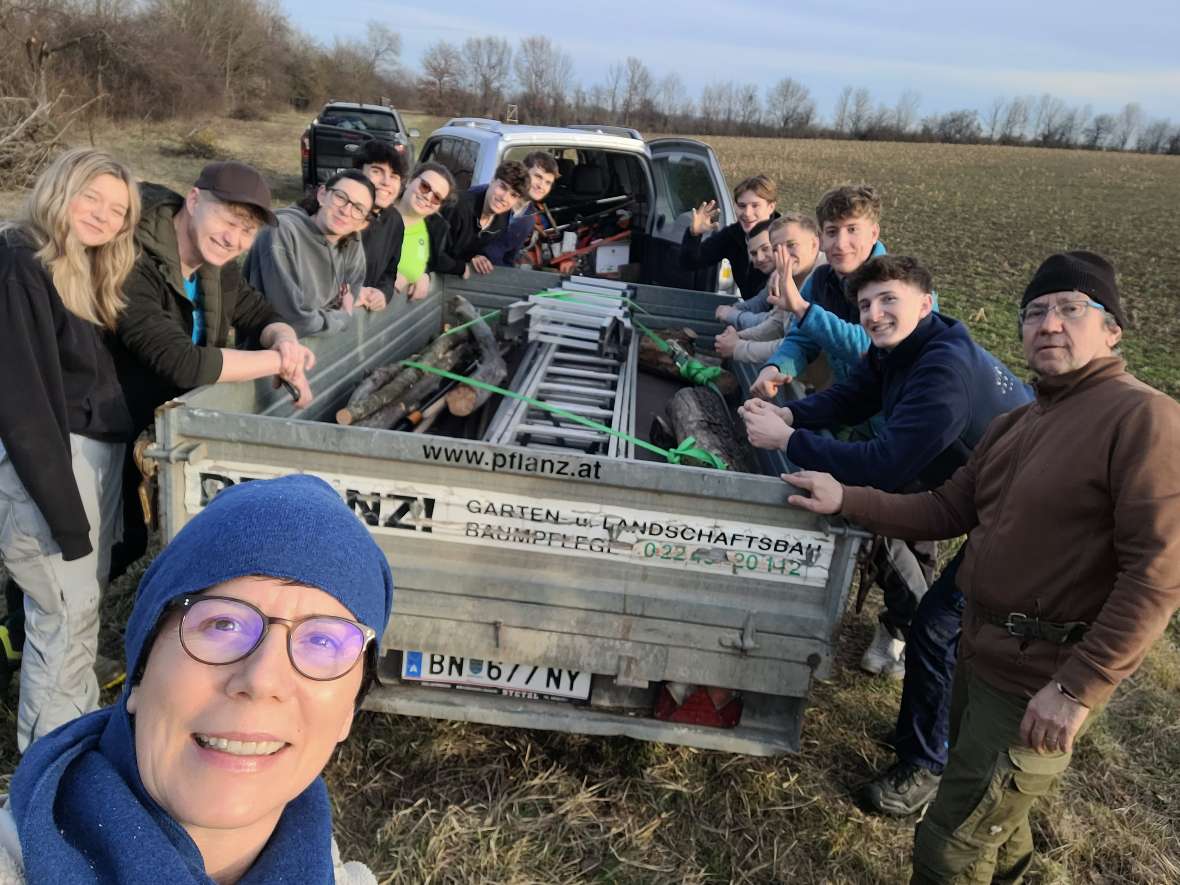 Gruppenfoto mit Schülerinnen und Schülern, Autoanhänger mit Leiter und Werkzeug