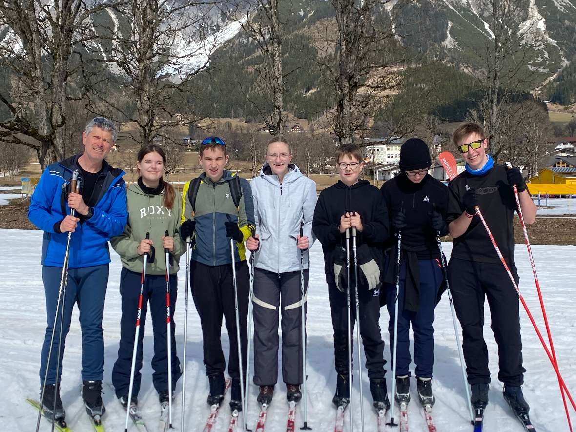 Langlaufgruppe mit Bergkulisse im Hintergrund