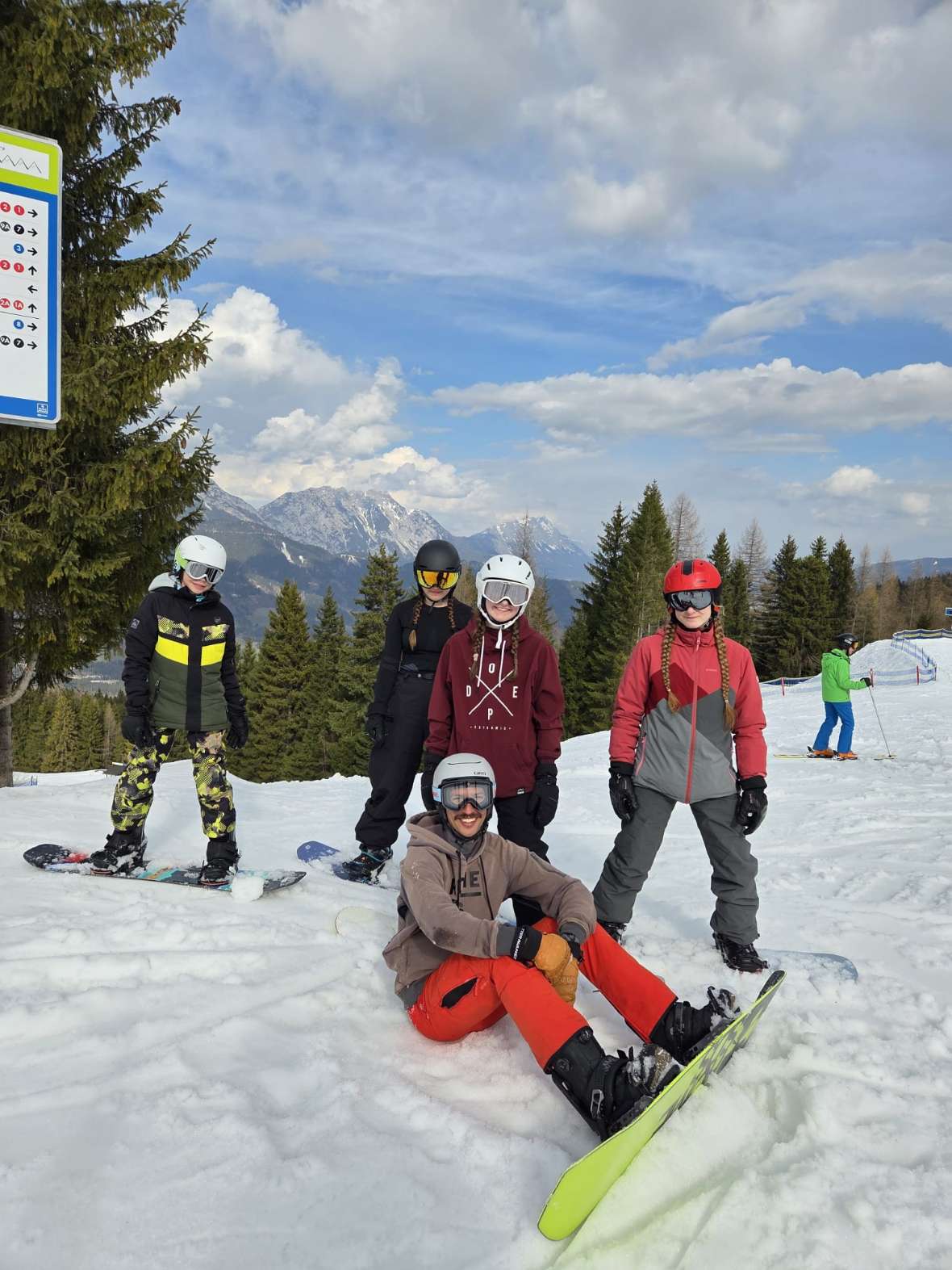 Snowboardgruppe mit Bergkulisse im Hintergrund