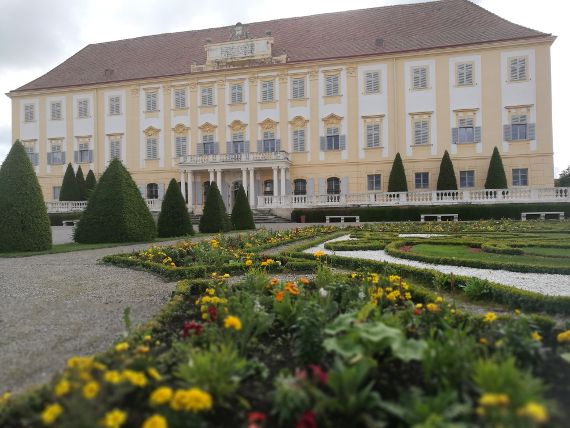 Barocke Fassade von Schloss Hof mit Blumenrabatten im Vordergrund